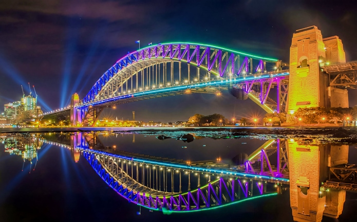 Sydney Harbour Bridge illuminated during Vivid Sydney, viewed from a dinner cruise.