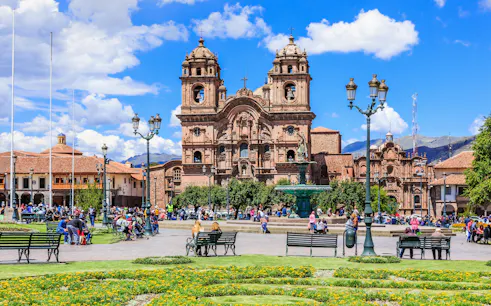 Plaza de Armas in Cusco, Peru with colonial architecture and people enjoying the square.