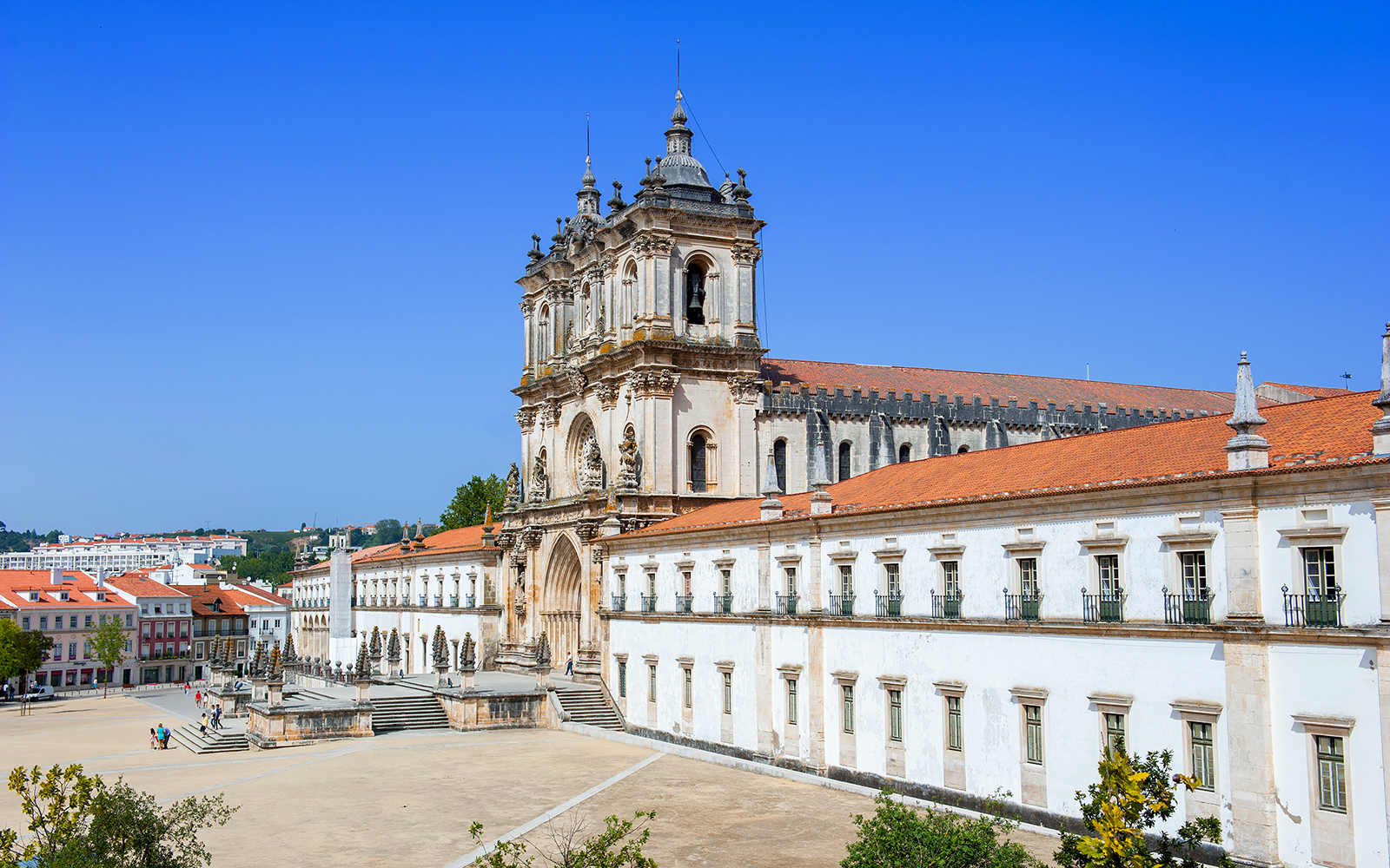 Alcobaça Monastery exterior with ornate facade and surrounding courtyard in Portugal.