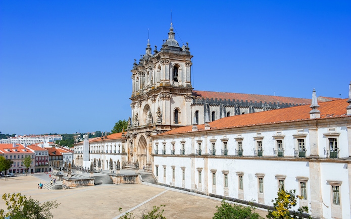 Alcobaça Monastery exterior with ornate facade and surrounding courtyard in Portugal.