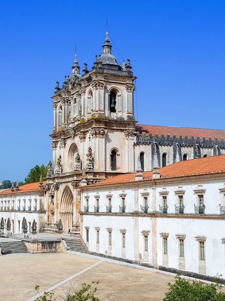 Alcobaça Monastery exterior with ornate facade and surrounding courtyard in Portugal.