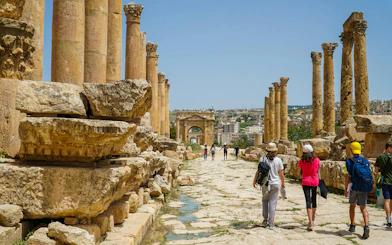 Tourists walking through ancient Roman ruins in Jerash, Jordan.