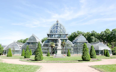 Greenhouse in Parc de la Tête d'Or, Lyon, France with surrounding greenery.