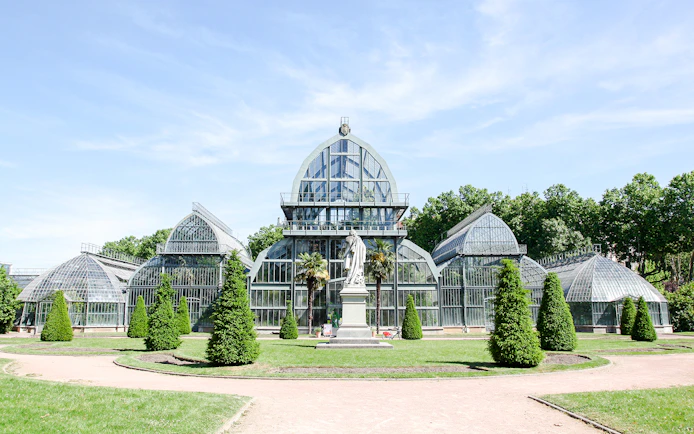 Greenhouse in Parc de la Tête d'Or, Lyon, France with surrounding greenery.