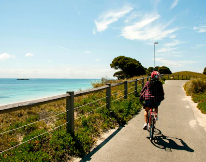Cyclist on a path along the coast of Rottnest Island, Australia.