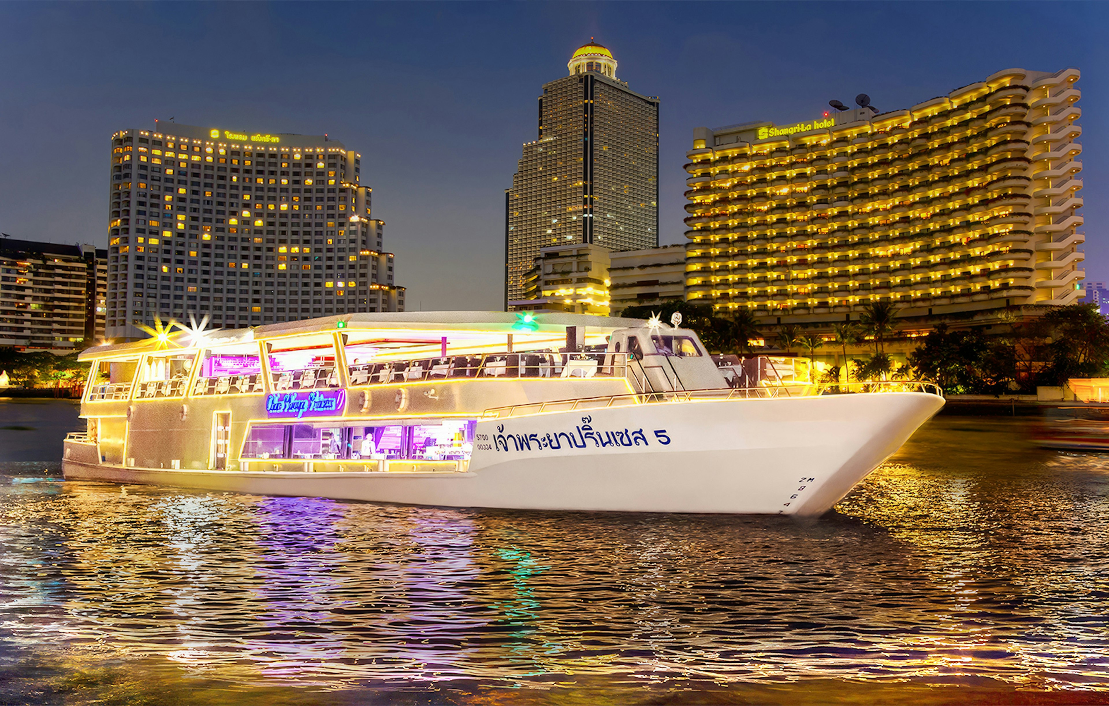 Chao Phraya Princess Cruise on river with Bangkok skyline at night.