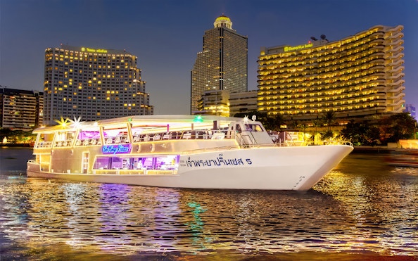 Chao Phraya Princess Cruise on river with Bangkok skyline at night.