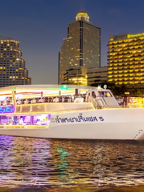 Chao Phraya Princess Cruise on river with Bangkok skyline at night.