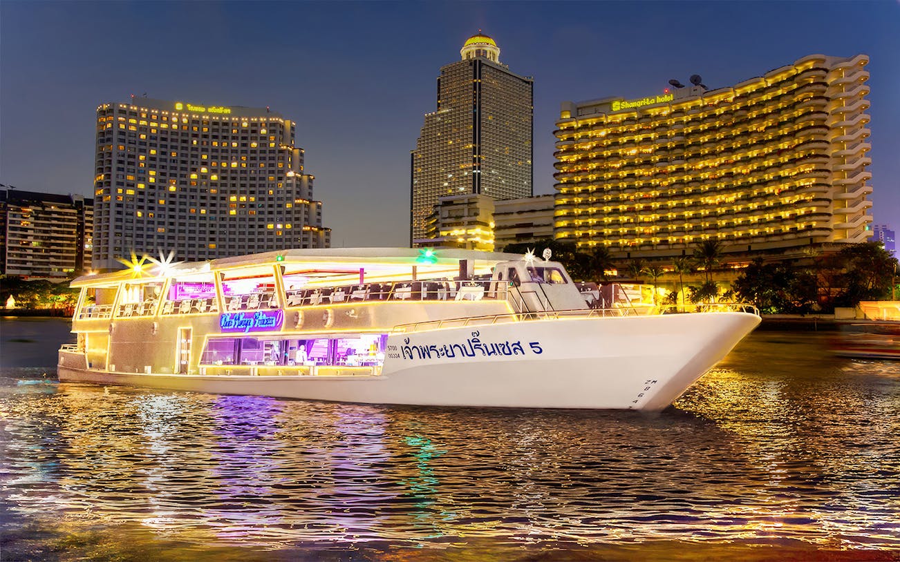 Chao Phraya Princess Cruise on river with Bangkok skyline at night.