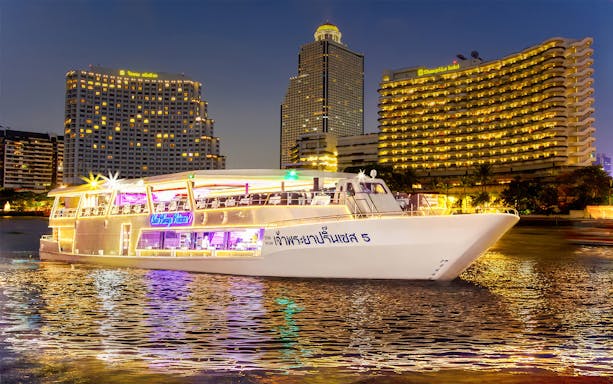 Chao Phraya Princess Cruise on river with Bangkok skyline at night.