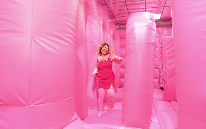 Person enjoying the pink bouncy house at the WONDR Experience in Amsterdam.