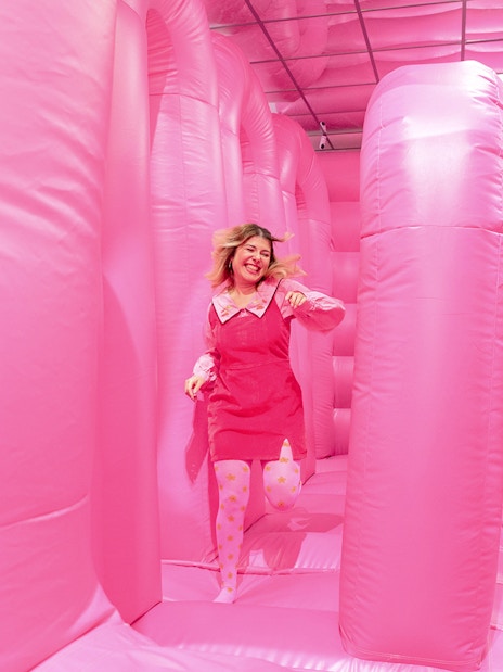 Person enjoying the pink bouncy house at the WONDR Experience in Amsterdam.
