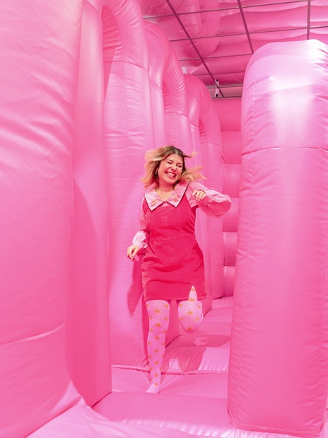 Person enjoying the pink bouncy house at the WONDR Experience in Amsterdam.