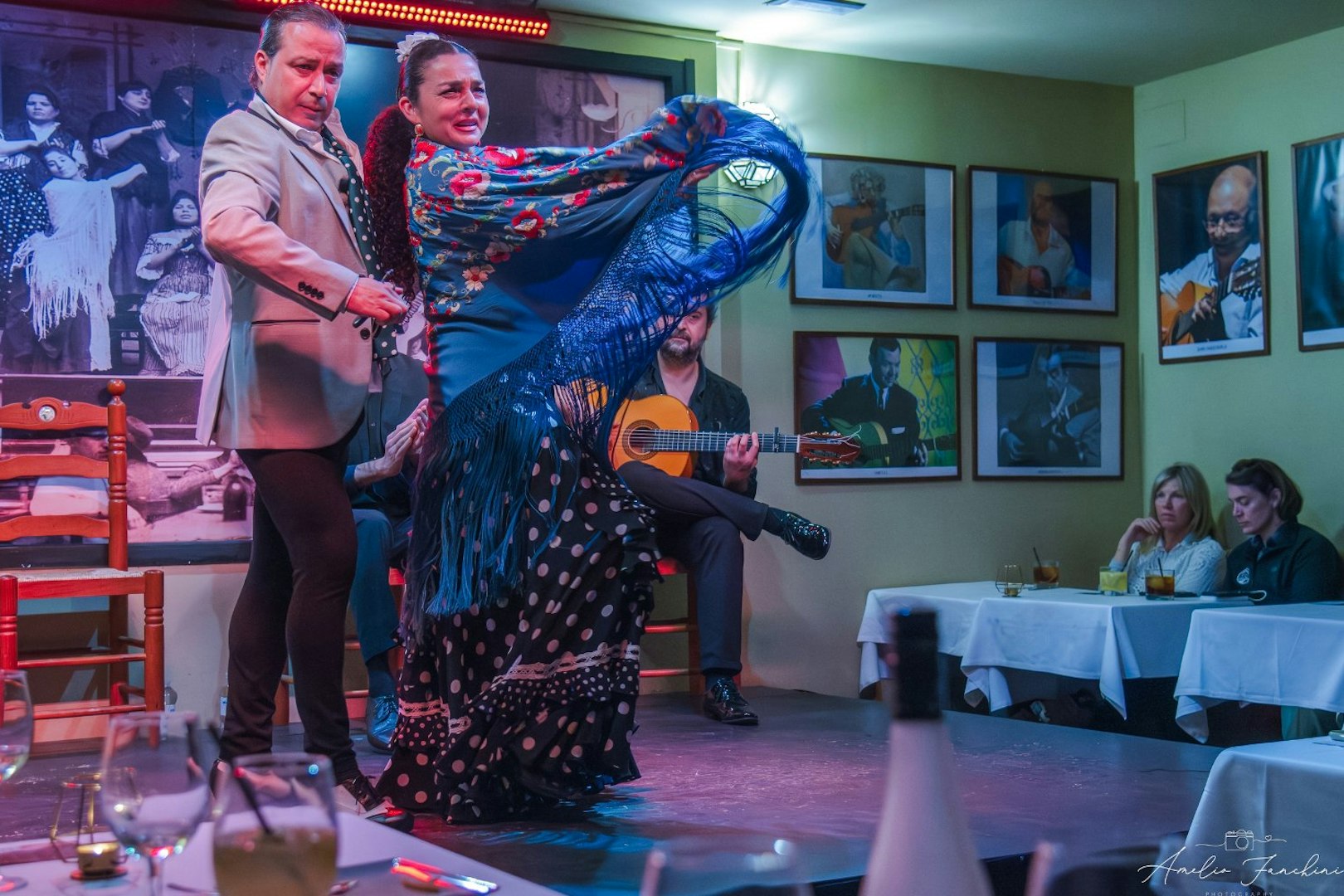 Flamenco dancers performing at Tablao La Cantaora, Seville with guitarist in background.