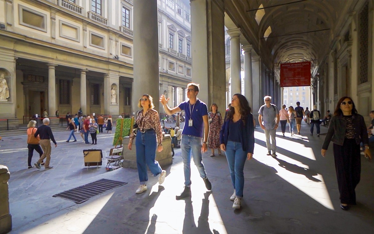 Tour group exploring Uffizi Gallery courtyard in Florence.