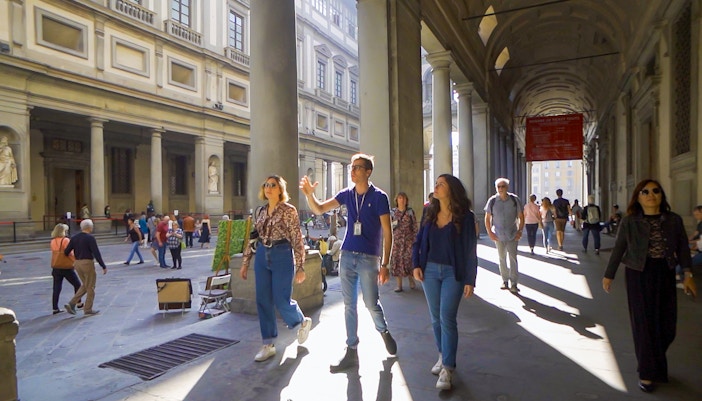 Tour group exploring Uffizi Gallery courtyard in Florence.