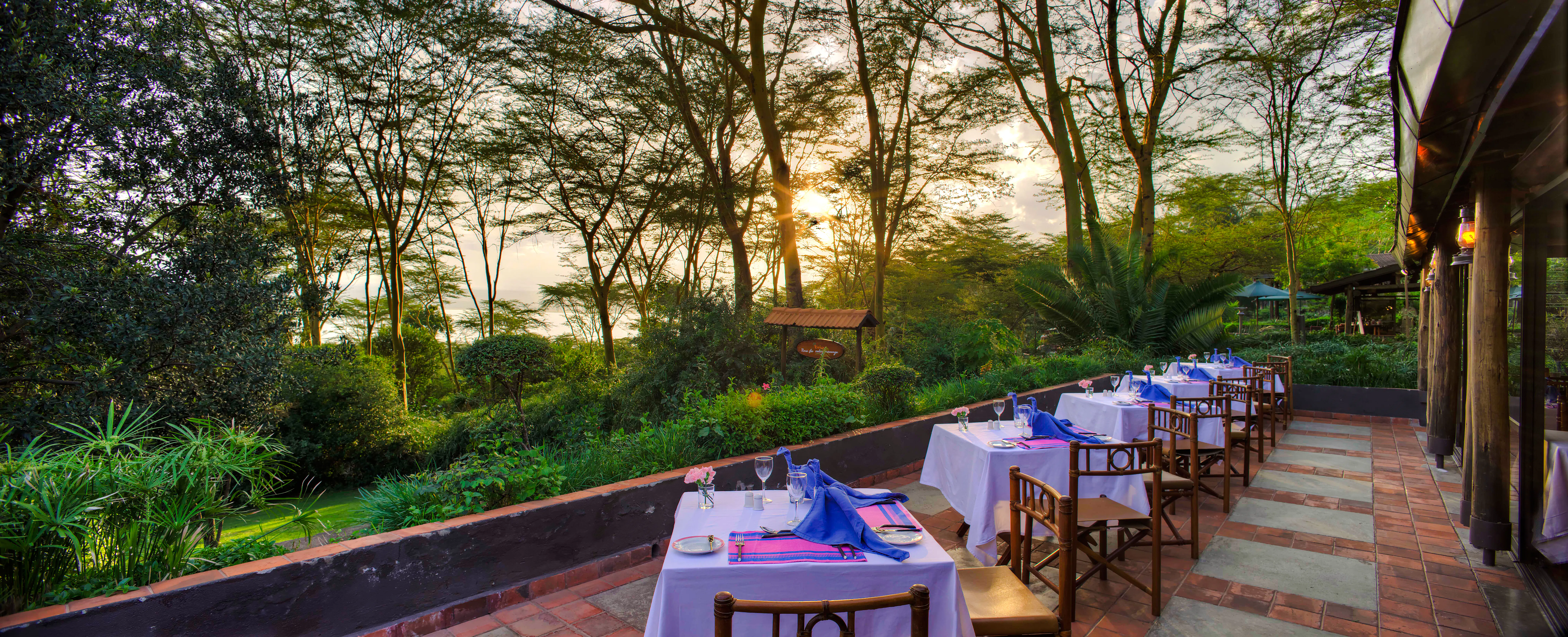 Outdoor dining setup at bush camp with sunset view, part of 2-Day Masai Mara Safari, Nairobi.
