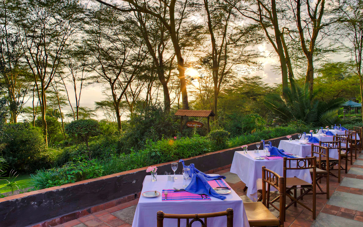 Outdoor dining setup at bush camp with sunset view, part of 2-Day Masai Mara Safari, Nairobi.