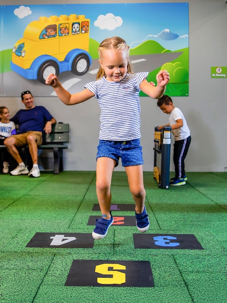 Child playing hopscotch at Duplo SchoolHouse, LEGOLAND Florida.