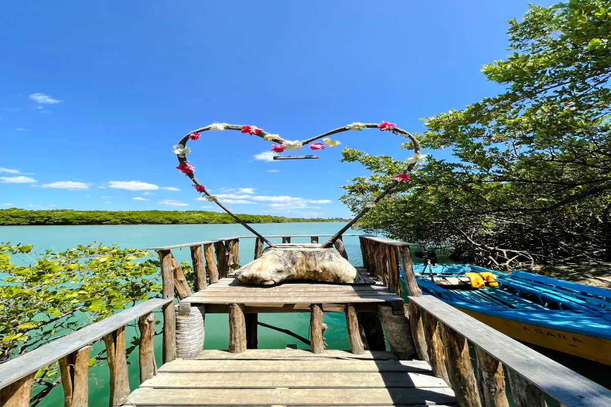 Wooden deck with heart-shaped arch overlooking mangrove waters in Icaraí de Amontada, Sao Paulo.