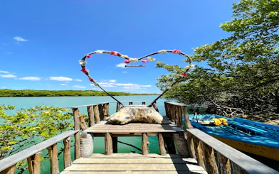 Wooden deck with heart-shaped arch overlooking mangrove waters in Icaraí de Amontada, Sao Paulo.