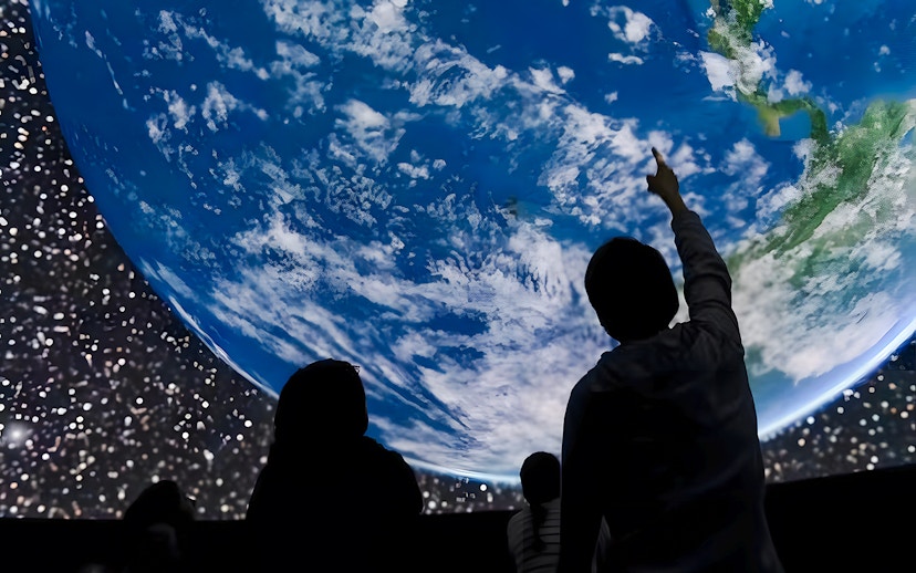 Visitors observing Earth projection at Planetarium, ARTIS Amsterdam Royal Zoo.