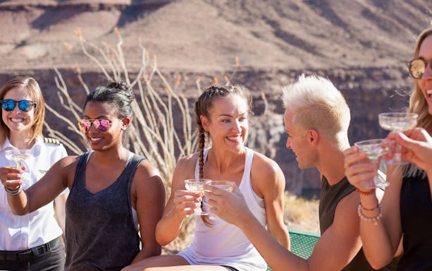 Group enjoying drinks at Grand Canyon after helicopter tour.