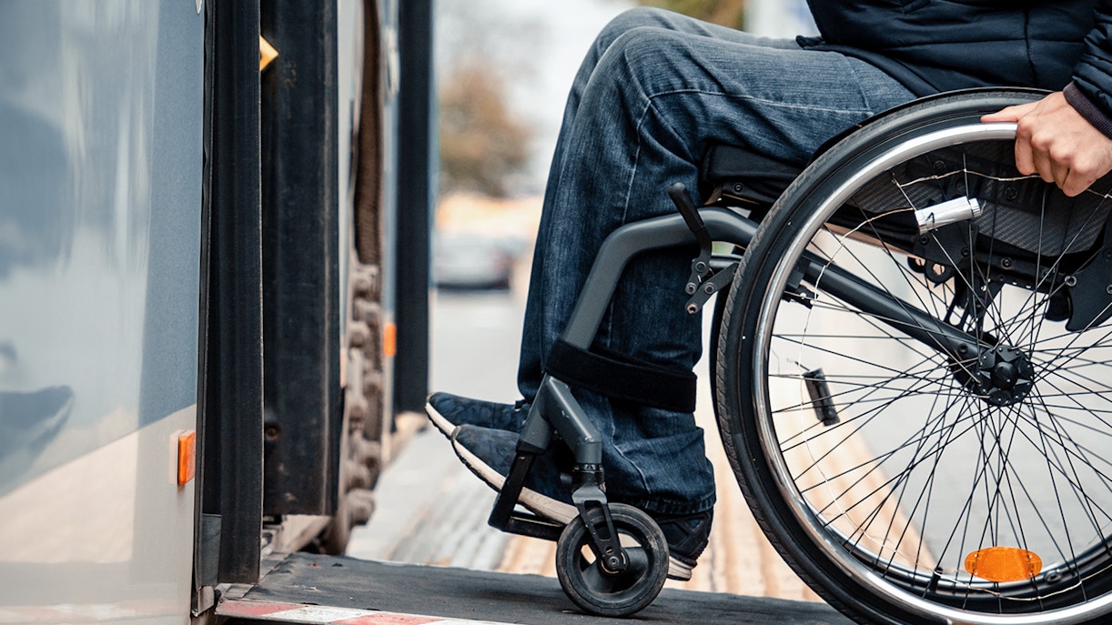 Wheelchair user boarding bus via accessible ramp.