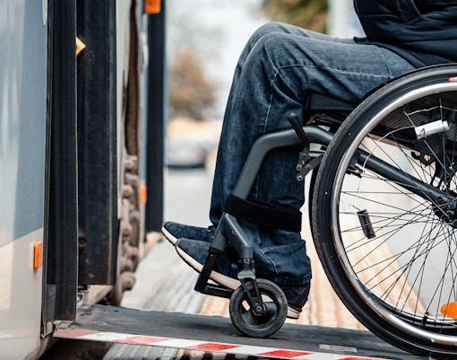 Wheelchair user boarding cruise via accessible ramp.