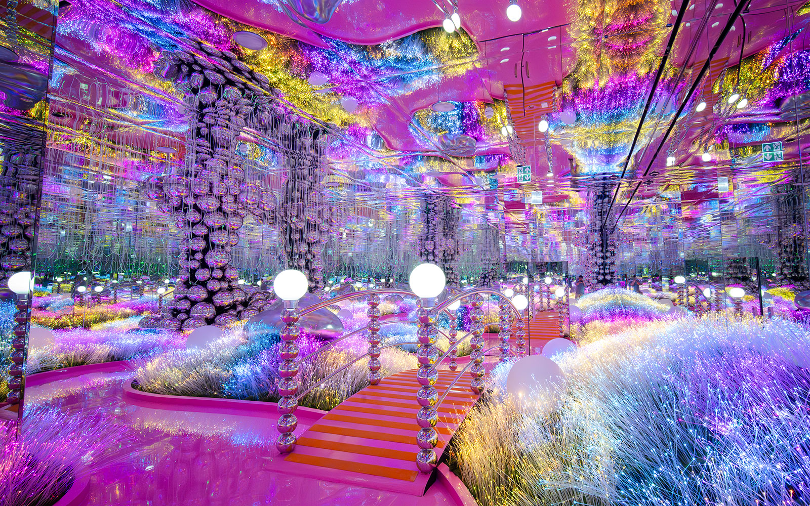 Colorful mirrored room with glowing lights and reflective surfaces at House of Hype, Dubai.