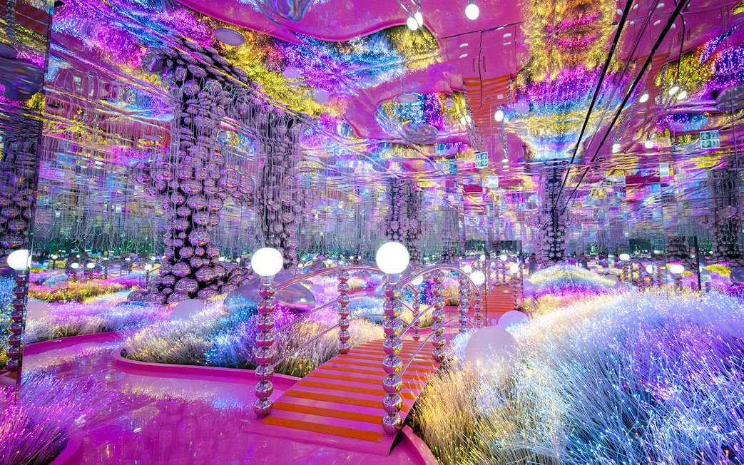 Colorful mirrored room with glowing lights and reflective surfaces at House of Hype, Dubai.