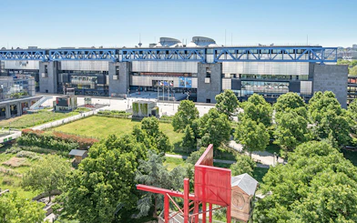 Science and Industry Museum in Paris with surrounding greenery and modern architecture.