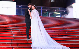 Couple posing on red stairs at Times Square, NYC during a photoshoot.
