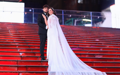 Couple posing on red stairs at Times Square, NYC during a photoshoot.