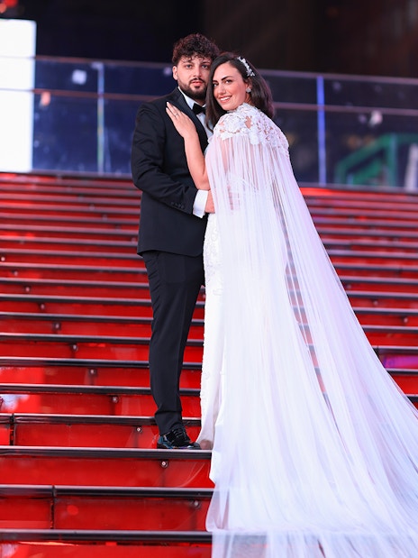 Couple posing on red stairs at Times Square, NYC during a photoshoot.