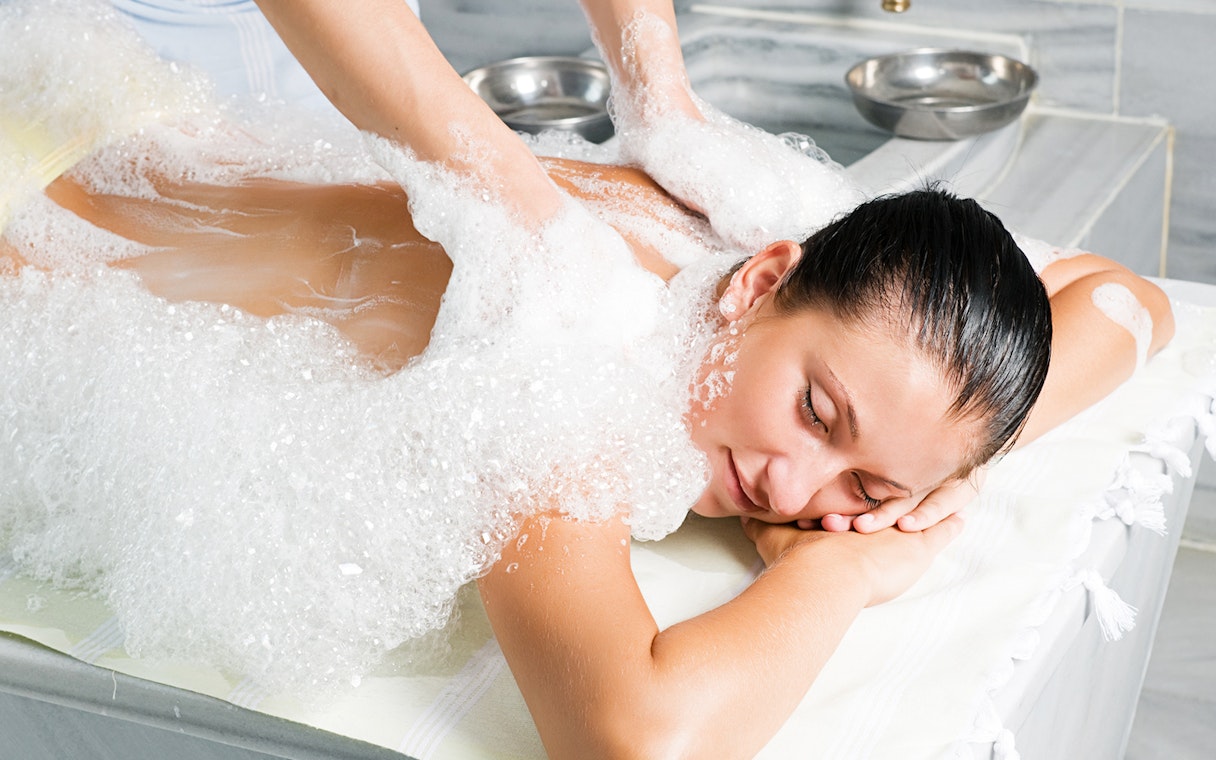 Person receiving a foam massage in a traditional Turkish bath in Antalya.