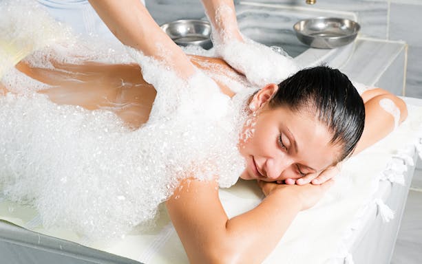 Person receiving a foam massage in a traditional Turkish bath in Antalya.