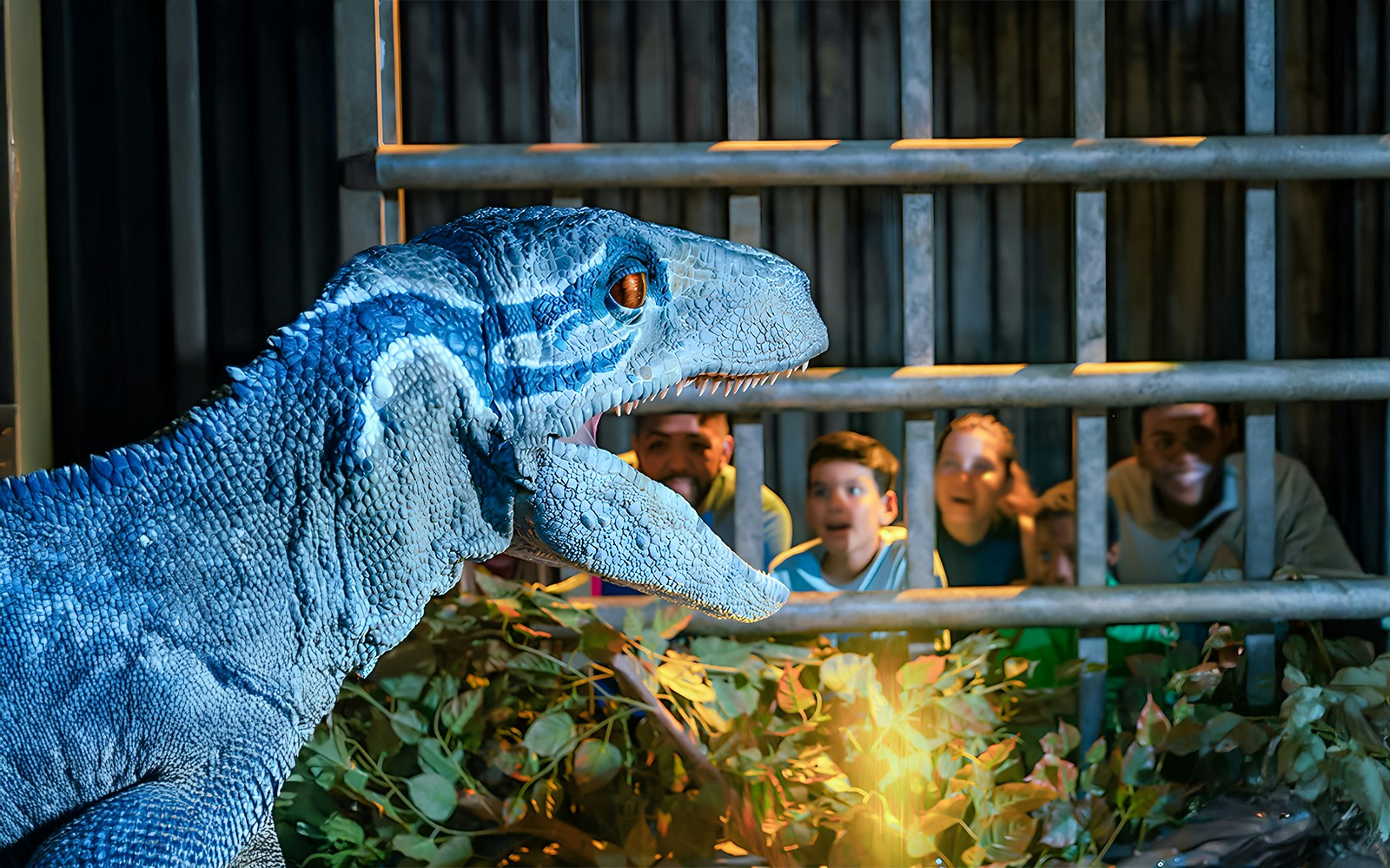 Velociraptor exhibit with visitors at Jurassic World Experience in London.