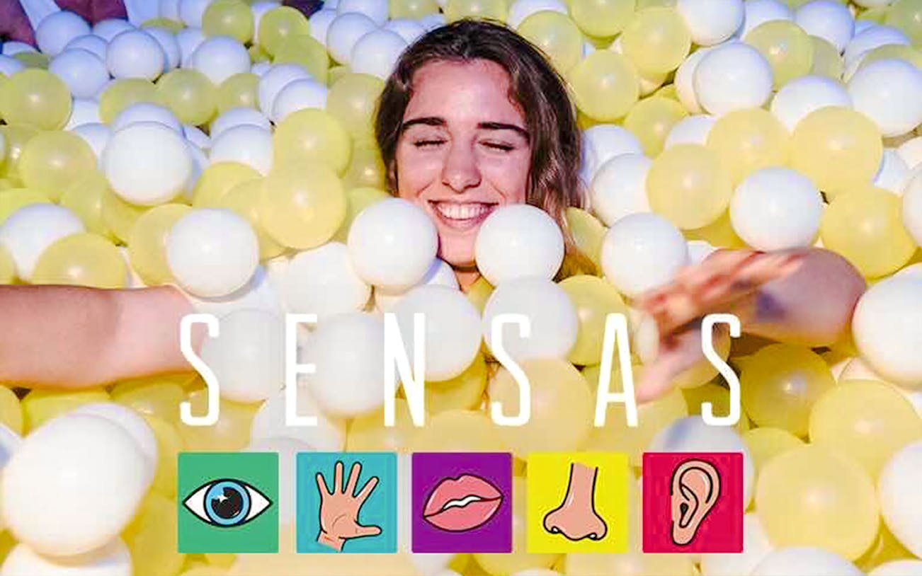 Person enjoying sensory experience in a ball pit at SENSAS.