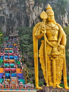 Golden statue of Lord Murugan and colorful steps at Batu Caves, Malaysia.