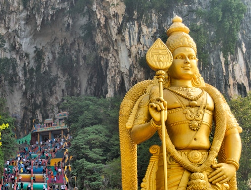 Golden statue of Lord Murugan and colorful steps at Batu Caves, Malaysia.