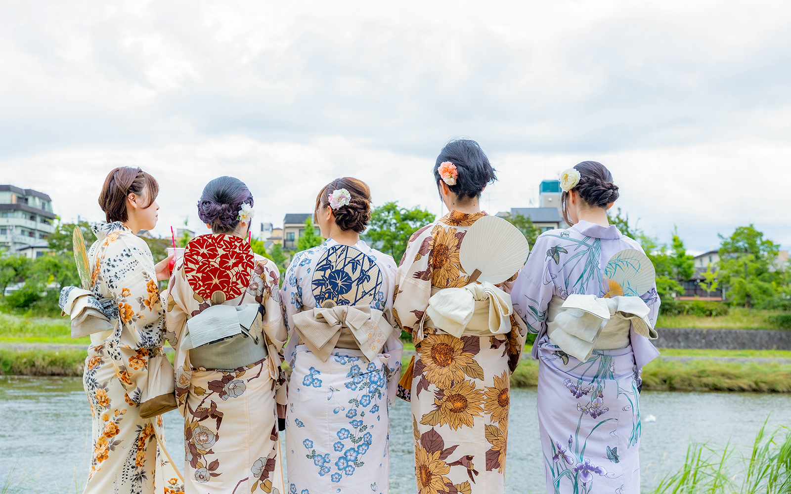 Women in kimonos by a river in Gion, Kyoto, during a full-day rental experience.