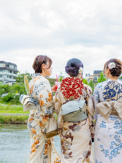 Women in kimonos by a river in Gion, Kyoto, during a full-day rental experience.