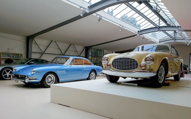 Classic Ferrari cars displayed in a modern showroom.