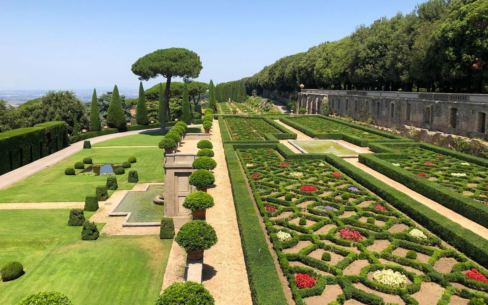 Castle Gandolfo garden with manicured hedges, fountains, and scenic pathways.
