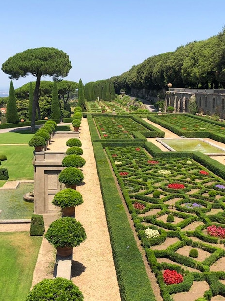 Castle Gandolfo garden with manicured hedges, fountains, and scenic pathways.