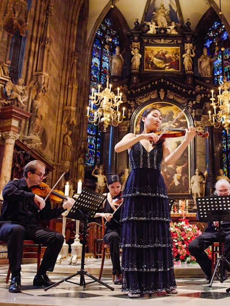 Performers playing string instruments inside St. Stephen's Cathedral, Vienna.