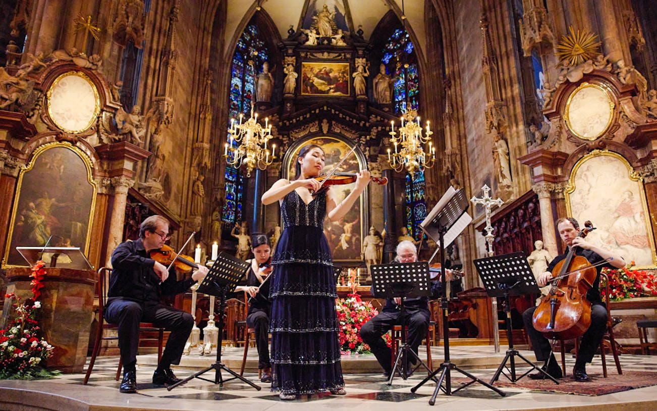 Performers playing string instruments inside St. Stephen's Cathedral, Vienna.