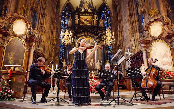 Performers playing string instruments inside St. Stephen's Cathedral, Vienna.