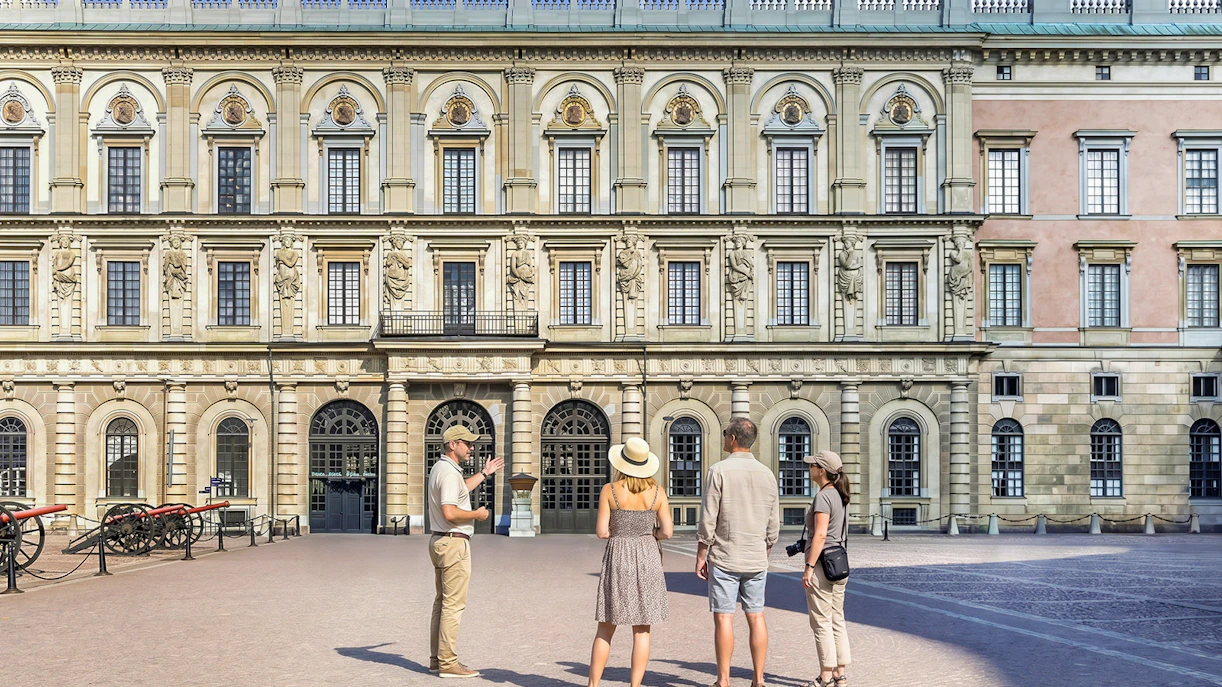Tour group in front of historic royal palace facade in Stockholm, Sweden.